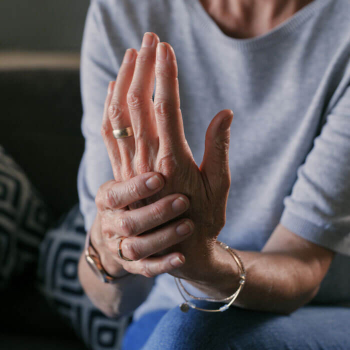 woman holding her hand in pain, suffering from carpal tunnel syndrome